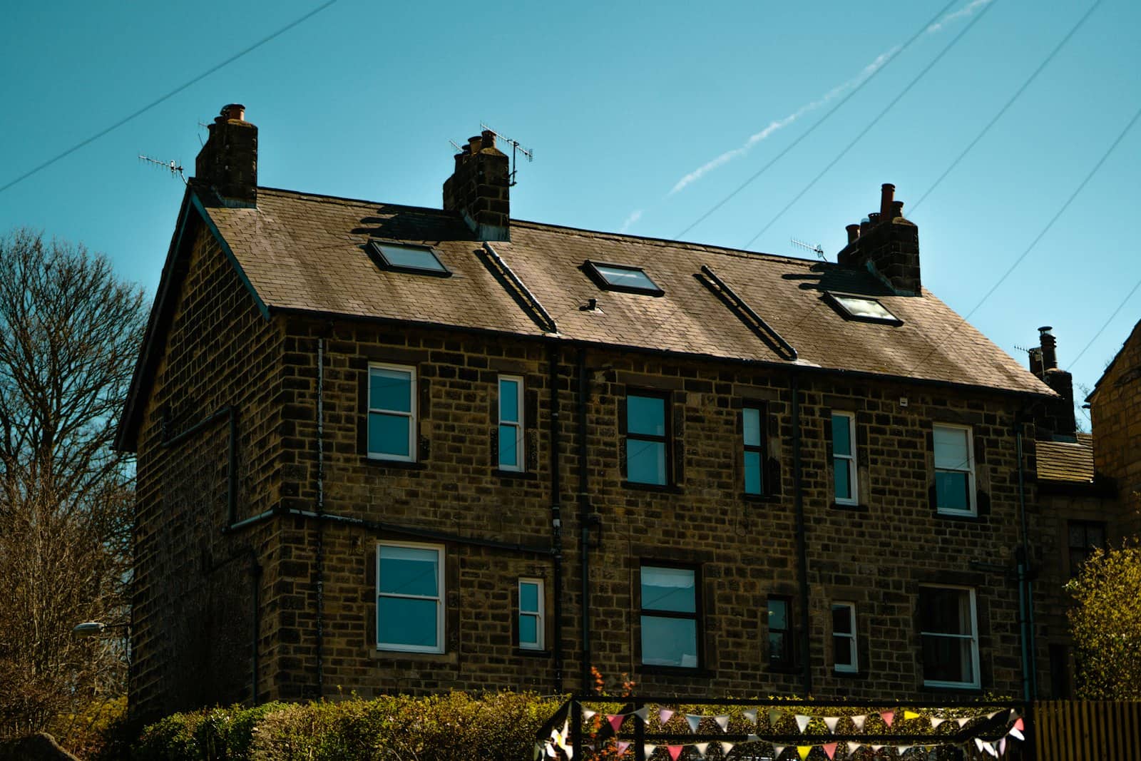 A stone-built semi-detached house under a clear sky